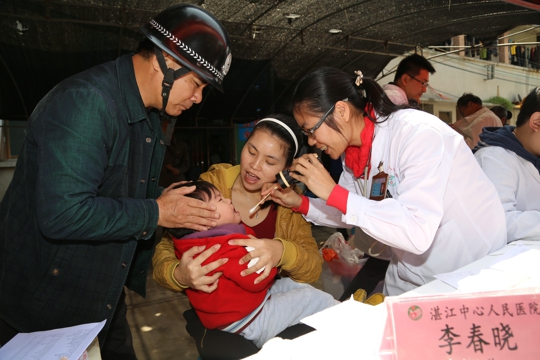 儿科医生为幼儿检查喉咙（翁冬宁摄）